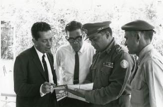 Dos militares y dos civiles revisando un mapa
