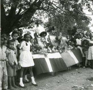 Mujeres y niños en un altar con una bandera