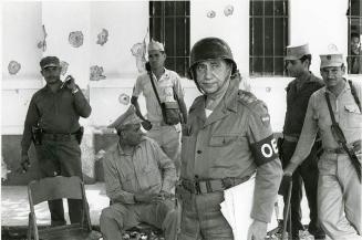 Varios militares, uno con brazalete de la OEA
