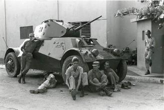 Soldados descansan junto a un carro de asalto