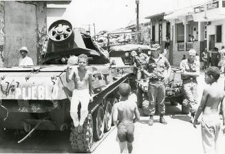 Soldados y niños junto a un tanque de guerra
