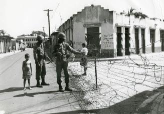 Dos soldados y un niño en la calle.