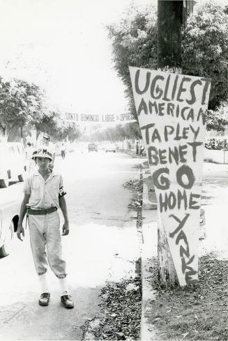 Soldado dominicano ante letrero escrito en inglés