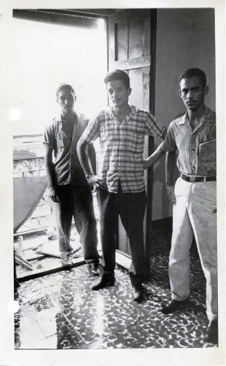 Tres jóvenes junto a una puerta