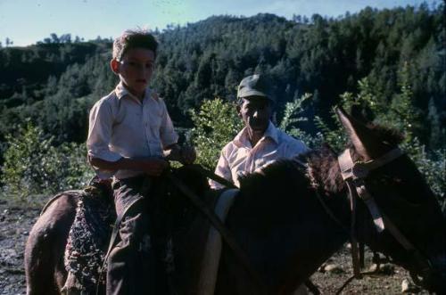 Campesino y niño en mulo