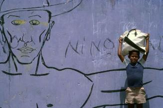 Niño junto a mural en Azua