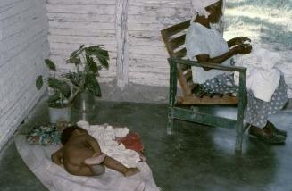 Señora y niño en interior de vivienda de Haina