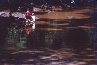 Mujer lavando en río