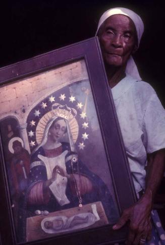 Anciana con imagen de la Virgen de la Altagracia