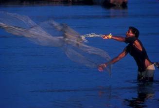 Pescador con red en aguas de Sabana de la Mar