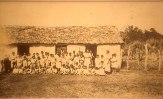 Vista de un grupo de estudiantes frente a una escuela rural 1919-1922